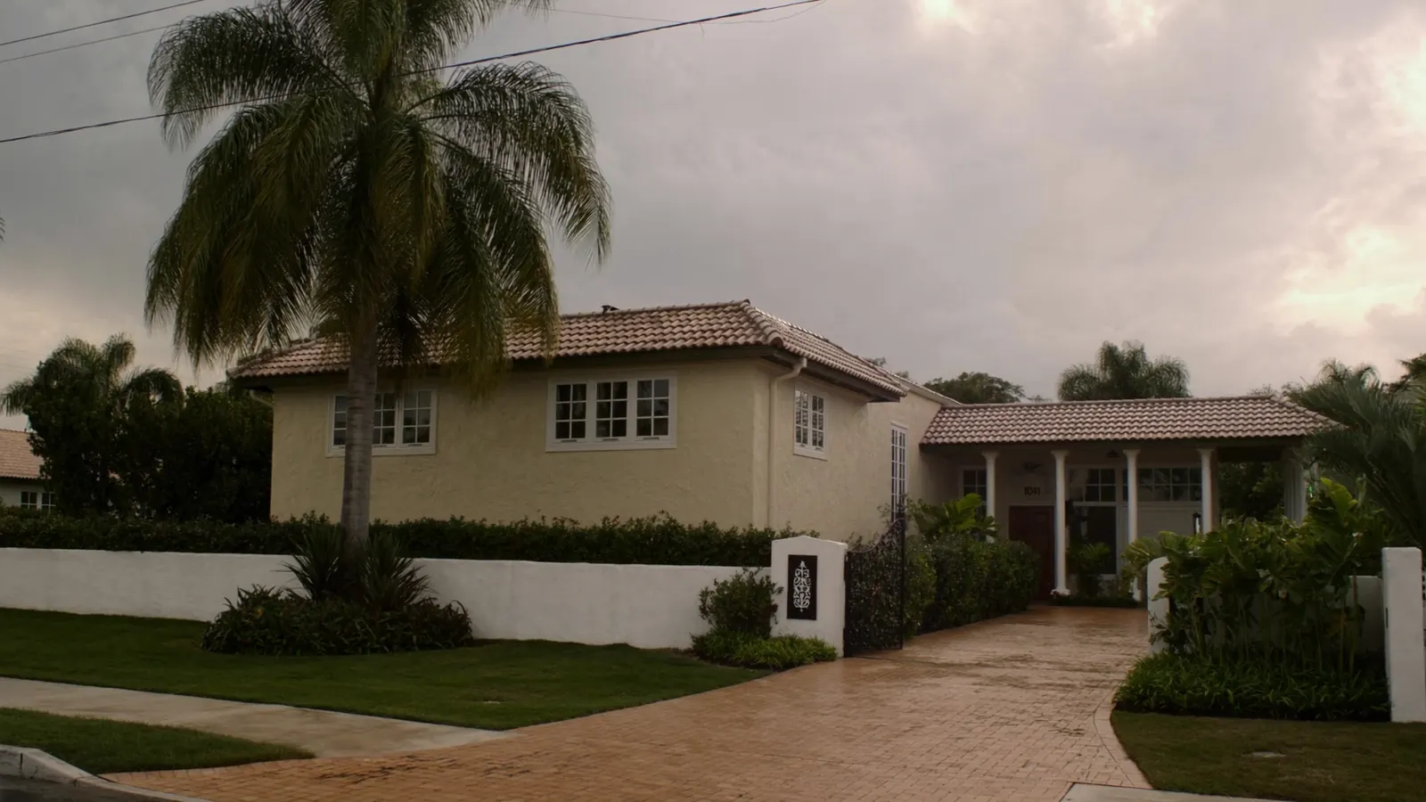 Cream stucco Miami home with wood trim where termite control is often needed